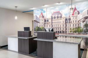 a lobby with a large mural of a building at La Quinta by Wyndham Latham Albany Airport in Latham