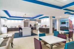 La Quinta by Wyndham Latham Albany Airport في لاثام: تقديم كافتيريا بالطاولات والكراسي