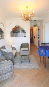 a living room with chairs and a chandelier at MARCOGDUR - Appartement pour 4 personnes à 100m de la plage situé aux Marines de Cogolin in Cogolin