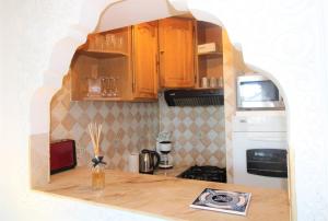 cocina con armarios de madera y encimera en MARCOGDUR - Appartement pour 4 personnes à 100m de la plage situé aux Marines de Cogolin en Cogolin
