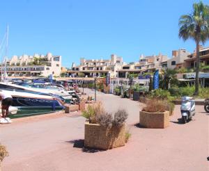 un puerto deportivo con una moto estacionada junto a un barco en MARCOGDUR - Appartement pour 4 personnes à 100m de la plage situé aux Marines de Cogolin en Cogolin