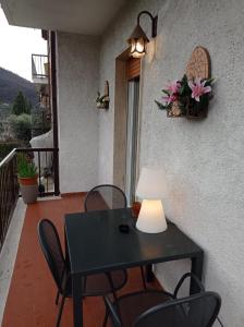 czarny stół z krzesłami i lampka na balkonie w obiekcie Casa Romolo w mieście Garda