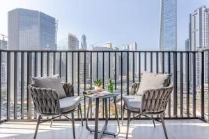 - un balcon avec deux chaises et une table donnant sur les toits de la ville dans l'établissement Frank Porter - Ahad Residences, à Dubaï