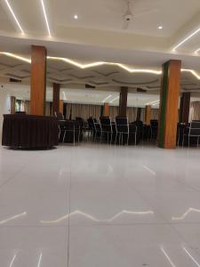 um salão de banquetes com cadeiras pretas e uma mesa em HOTEL SIGNATURE INN em Ambikāpur