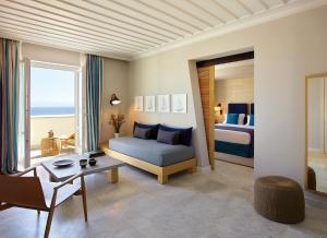 a living room with a bed and a couch and a table at Summer Senses Luxury Resort in Logaras