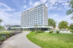 Parkhotel Heilbronn في هايلبرون: مبنى أبيض طويل مع حديقة أمامه