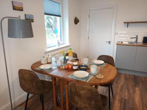 una mesa de comedor con platos y comida. en Connemara Lake View Apartment, en Camus Eighter