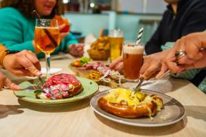 a group of people sitting at a table with plates of food at The People - Strasbourg in Strasbourg