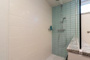 a shower in a bathroom with green tiles at Am Höhlchen in Olsberg +38 photos