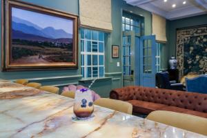 a dining room with a table with a vase on it at The Monarch Hotel in Johannesburg