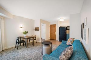 Sonesta ES Suites San Diego - Sorrento Mesa في Sorrento: غرفة معيشة مع أريكة زرقاء وطاولة