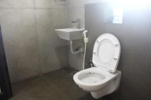 a bathroom with a toilet and a sink at Maa Ghara Gokul Bhawan in Bhubaneshwar