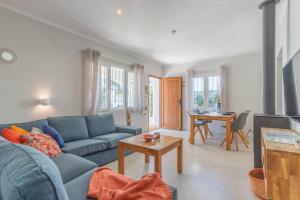ein Wohnzimmer mit einem blauen Sofa und einem Tisch in der Unterkunft Villa Family Moraira Style in Moraira