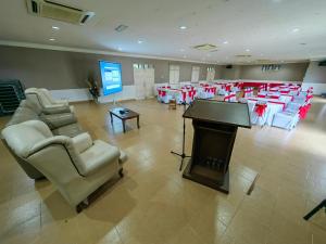 a large room with a piano and chairs and a stage at Marang Village Resort in Marang