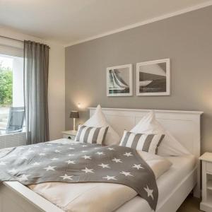 a white bedroom with a bed with stars on it at Ferienwohnung - Michaelas HUUS - zwischen den Meeren, Trappenkamp in Trappenkamp