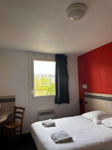 une chambre d'hôtel avec un lit et une fenêtre dans l'établissement Brit Hotel La Ferté sous Jouarre, à La Ferté-sous-Jouarre