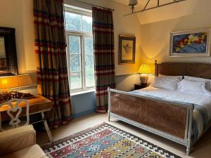 um quarto com uma cama, uma secretária e uma janela em The Old Rectory em Kings Lynn