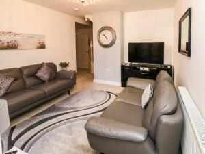 a living room with a couch and a flat screen tv at 9 Seaford Sands in Paignton