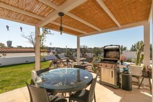 un patio avec une table, des chaises et un barbecue dans l'établissement Rome Design Villa, à Rome