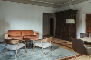 uma sala de estar com um sofá, uma mesa e cadeiras em Arthotel Lasserhaus em Brixen