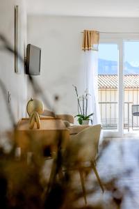 - un salon avec une table, une chaise et une fenêtre dans l'établissement La Manufacture D'oriano LES NUITS AU VILLAGE, à Montegrosso