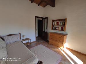 ein Schlafzimmer mit einem Bett und einer Holzkommode in der Unterkunft Agriturismo Asara in Padru