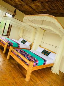 a bedroom with two beds in a room at Bwindi Neckview Lodge in Buhoma