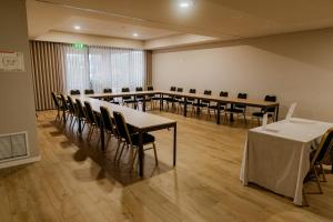 a conference room with tables and chairs in a room at Meu Hotel Porto Gandra in Paredes