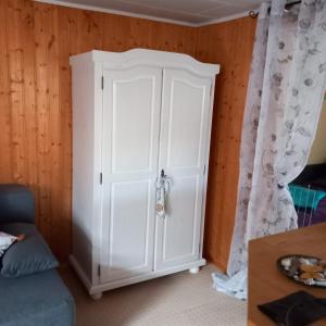 Armario blanco en una habitación con sofá en Bungalow kleine Auszeit, en Stiege