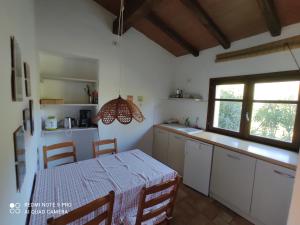 eine Küche mit Tisch und Esszimmer in der Unterkunft Agriturismo Asara in Padru