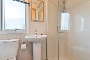 a white bathroom with a sink and a shower at Tattershall Lakes: Sally's Superior Stay in Tattershall +37 photos