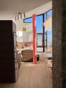 a kitchen with a refrigerator and a table in a room at Vivienda La Majorera, tranquila , luminosa, acogedora in Puerto del Rosario