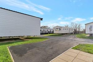 a row of white buildings in a parking lot at Tattershall Lakes: Sally's Superior Stay in Tattershall