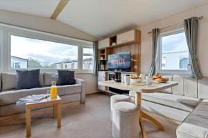 a living room with a couch and a table at Tattershall Lakes: Sally's Superior Stay in Tattershall