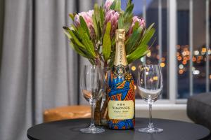 - une bouteille de champagne et deux verres sur une table dans l'établissement The Hub 602 by Host Agents, au Cap 16 autres photos
