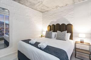 une chambre avec un grand lit blanc avec des serviettes dessus dans l'établissement The Hub 602 by Host Agents, au Cap