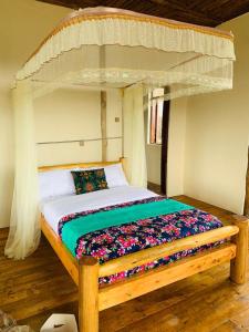 a bedroom with a wooden bed with a canopy at Bwindi Neckview Lodge in Buhoma