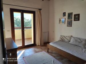 ein Wohnzimmer mit Sofa und Glasschiebetür in der Unterkunft Agriturismo Asara in Padru