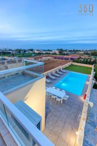 uitzicht op het zwembad vanaf het balkon van een huis bij LUX Villa with Private Pool, BBQ & Rooftop Oasis by 360 Estates in Kalkara