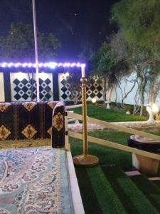 a garden with a table and lights on it at شاليه السلوى in Hafr Al Baten