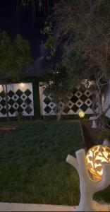 un patio con una valla y una silla blanca en el césped en شاليه السلوى, en Hafr Al Batin