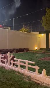 a fence in front of a yard at night at شاليه السلوى in Hafr Al Baten