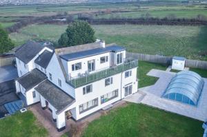 an aerial view of a white house with a greenhouse at The Penthouse - 1 Bedroom Apartment - Ocean Breeze in Port-Eynon