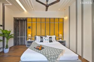 um quarto com uma cama e uma parede amarela em EKOSTAY Gold - Peninsula Villa em Lonavala