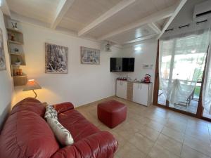un soggiorno con divano rosso e TV di Affittimoderni Viddalba - Villaggio Casteldoria a Viddalba