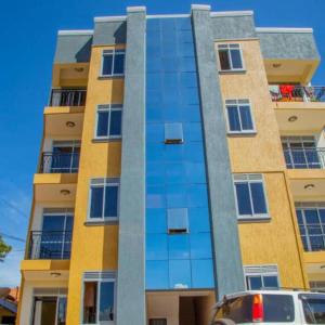 een hoog gebouw met glazen ramen aan de zijkant bij Spacious- Brb Homes Bukoto in Kampala