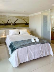 a bedroom with a large bed with two towels on it at Flat no Brasília Lider, 14º Andar in Brasilia