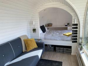 a room with a bed and a couch in it at Jam First - Lydcott Glamping, Cornish Sea Views in East Looe