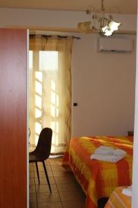 MirtoにあるAgriturismo Fonte Madonnaのベッドルーム1室(ベッド1台、椅子、窓付)