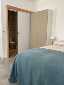a bedroom with a bed with a blue blanket at Studio - Cœur de Ville in Sérignan